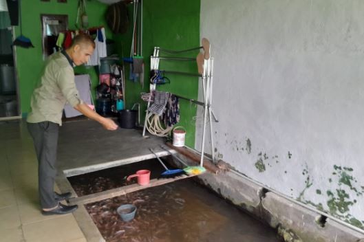  Ade Supriadi Rukmana Putra sedang beraktivitas memberikan pakan ikan nila. (Foto: iNews Media Group)