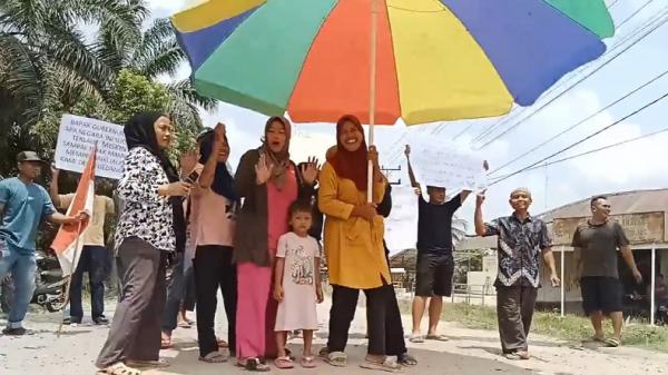 Sindir Pemerintah, Emak-Emak Pakai Payung Besar Mendadak Jadi Model di Tengah Jalan Asahan<