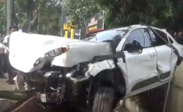 Mobil Porsche ringsek usai menabrak Avanza dan warung hingga terbang dan tersangkut pagar Kantor Sat Samapta Polrestabes Medan, Rabu (8/5/2024). (Foto: iNews)