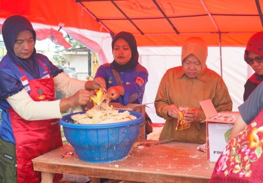 Mensos Risma ikut membantu mengolah makanan bagi para pengungsi korban banjir lahar dingin Sumatera Barat. (Foto: ist)