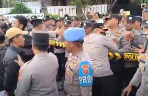 Puluhan mahasiswa terlibat aksi saling dorong dengan petugas saat demo menuntut penuntasan kasus Vina di depan Polres Cirebon Kota, Rabu (19/6/2024). (Foto: iNews/Toiskandar)