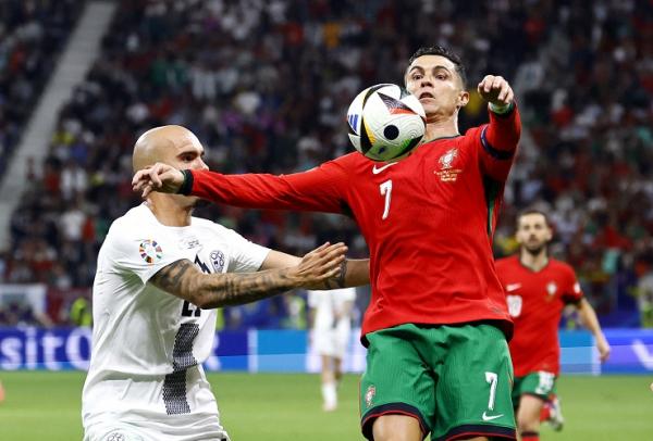 Kapten Timnas Portugal Cristiano Ronaldo (7) dikaw Kapten Timnas Portugal Cristiano Ronaldo (7) dikawal pemain Slovenia Vanja Drkusic pada 16 besar Euro 2024 di Waldstadion, Frankfurt, Jerman, Selasa (2/7/2024) dini hari WIB. (Foto: REUTERS)