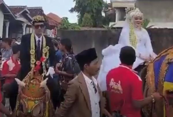 Viral pasangan pengantin sesama anggota marching band diarak dengan naik kuda di Bangkalan. (Foto: iNews)