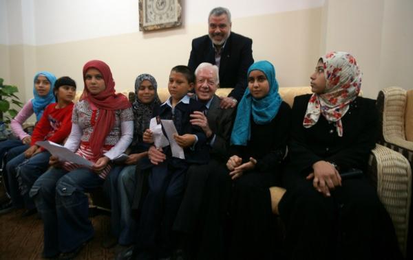Ismail Haniyeh (belakang) bersama Presiden ke-39 AS Jimmy Carter (duduk, ketiga dari kanan) dan anak-anak Gaza pada Juni 2009. (Foto: EPA)