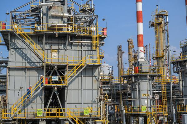 Dua petugas berjalan di area unit Kilang Pertamina Internasional Unit Dumai, Kota Dumai, Riau.