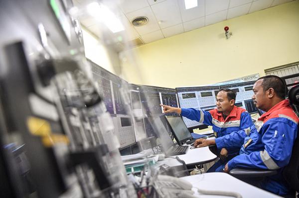 Pekerja melakukan pengamatan di ruang kontrol
