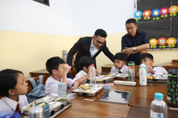Juru Bicara Kantor Komunikasi Kepresidenan Dedek Prayudi bercengkrama dengan siswa SD Barunawati saat kick off Makan Bergizi Gratis. (Foto: iNews Media Group/Arif Julianto)