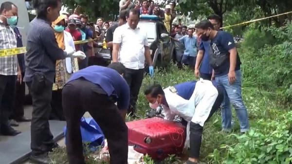 Petugas saat mengevakuasi mayat dalam koper di lokasi tempat pembuangan sampah Desa Dadapan, Kecamatan Kendal, Kabupaten Ngawi, Jawa Timur, Kamis (23/1/2025). (Foto: iNews/Asfi Manar)