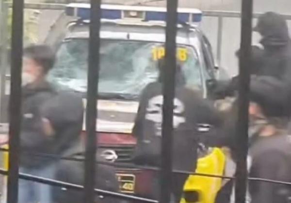 Massa berpakaian hitam merusak mobil patroli polisi saat aksi May Day di Kota Bandung, Kamis (1/5/2025). (Foto: iNews)