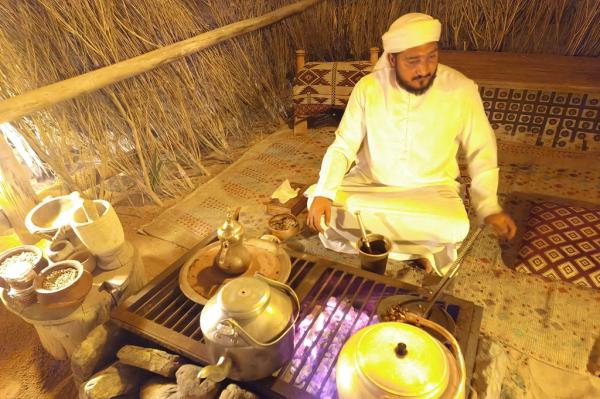 Seorang pria menyiapkan kopi Arab untuk disuguhkan kepada para wisatawan sebelum menikmati makan malam di tenda mewah ala Bedouin. (iNews.id/Maria Christina Malau)