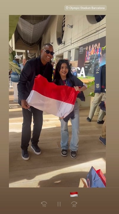 Patrick Kluivert berfoto dengan seorang fans wanit Patrick Kluivert berfoto dengan seorang fans wanita yang membawa bendera Merah Putih seusai laga El Clasico Barcelona vs Real Madrid, Minggu (11/5/2025) malam WIB. (Foto: Instagram @patrickkluivert9)