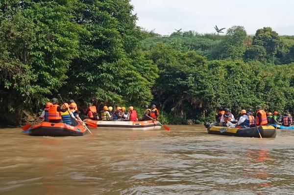 Relawan menyusuri Sungai Cikeas dengan perahu karet, memunguti sampah yang tersangkut. (Foto: IMG/Reza Fajri)