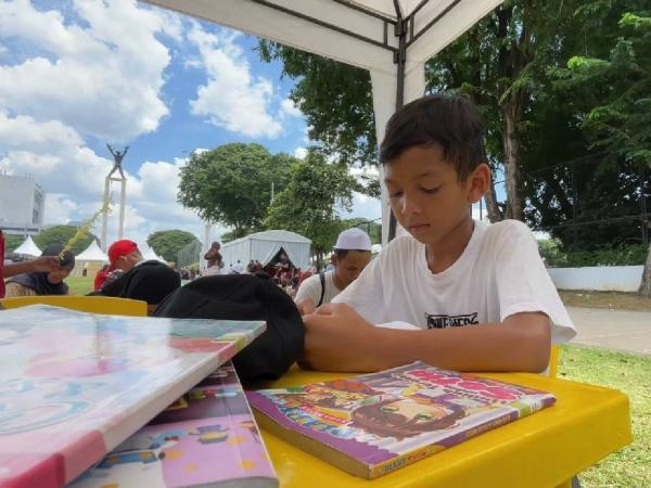 Bocah baca buku Salah satu sudut di acara Lebaran Betawi 2026 di Lapangan Banteng, Jakarta Pusat, Minggu (12/4/2026). (Foto: Niko Prayoga)