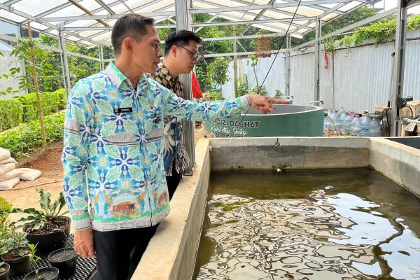 Lurah Pegangsaan Dua, Sarmudi saat meninjau kolam budidaya ikan lele di Kebun Gangnam. (Foto: Rizky Agustian)