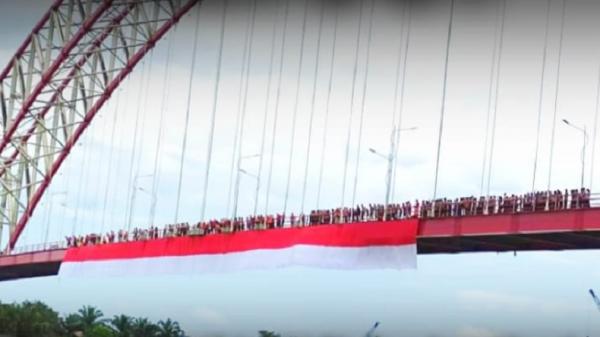 Gugah Rasa Cinta Tanah Air, Merah Putih Sepanjang 100 Meter Dibentang di Jembatan Kutai Kartanegara