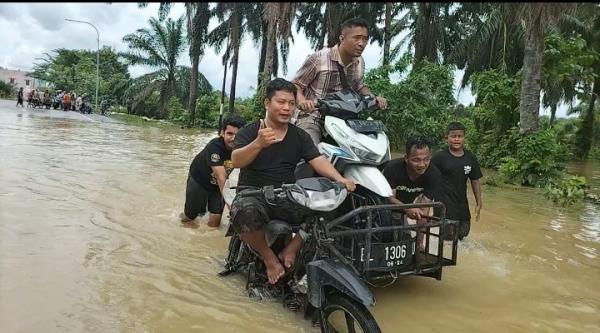 Manfaatkan Banjir, Warga Mengais Rezeki Menjadi Ojek Barang Sebrangkan Sepeda Motor Melintasi Banjir