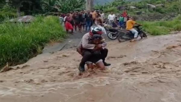 Takut Banjir, Anggota Bhabinkamtibmas  Maumere NTT Digendong Warga ke Seberang