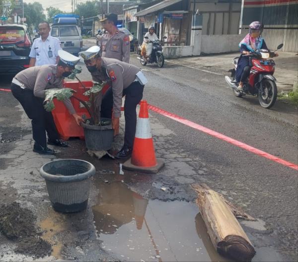 Demi Tambal Jalan Lubang, Polisi Blitar Rela Gotong Karung Pasir