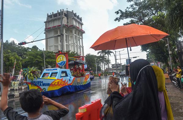 Potret Warga Bertahan Menonton Karnaval Budaya HUT Palembang Meski Turun Hujan
