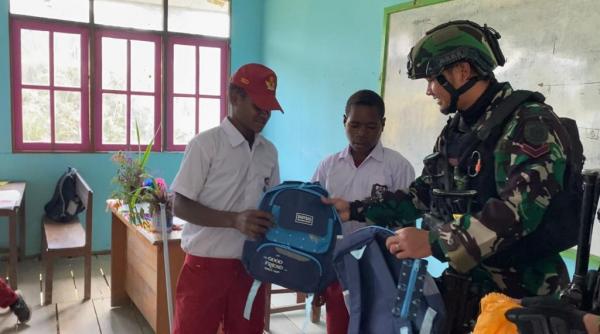 Peduli Generasi Penerus Bangsa, Satgas YPR 330/Tri Dharma Bagikan Tas dan Buku untuk Anak Sekolah