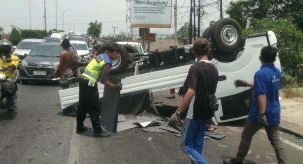 Pecah Ban, Mobil Pickup Muatan Plat Besi Terbalik di Cilegon