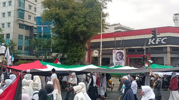 Puluhan Peserta Aksi Akbar Membentangkan Bendera Raksasa Palestina Menuju Monas