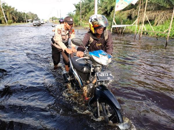 Polisi di Bandar Sei Kijang Bantu Warga Terdampak Banjir, Sampaikan Pesan Kamtibmas Pemilu