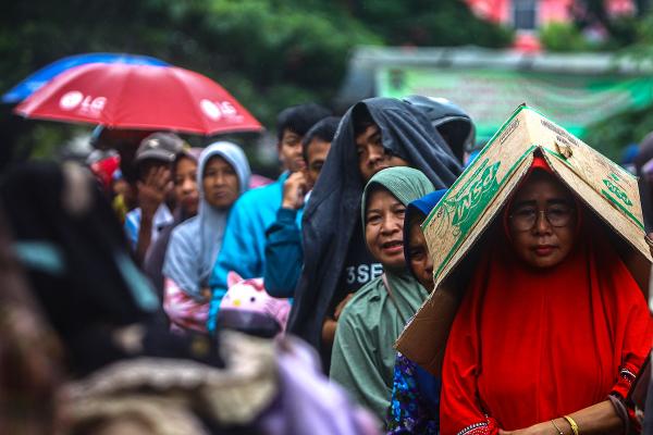 Potret Warga Antre Beli Beras di Bawah Rintik Hujan
