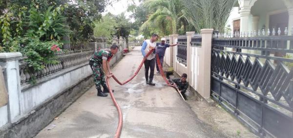 Anggota Koramil 18 Tripa Pidie Jaya Bantu Warga Bersihkan Saluran Air Tersumbat Lumpur di Desa Binaa