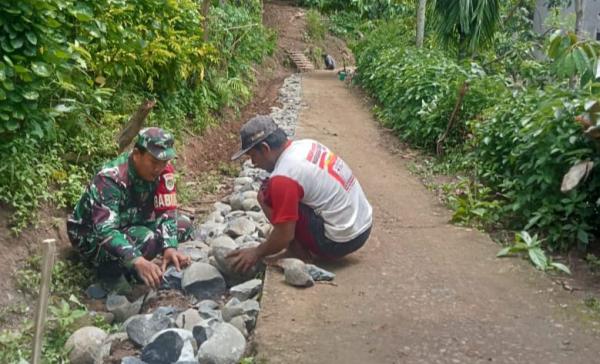 Babinsa Koramil 0608-17/Cidaun Bantu Warga Kampung Pasir Panjang Kerja Bakti Pelebaran Jalan