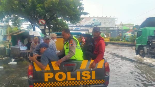 Polisi Basah Kuyup Bantu Pengendara Terjebak Banjir di Semarang