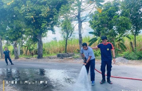 Petugas Damkar Bersihkan Pasir Bekas Perbaikan Jalan yang Sebabkan Pengendara Jatuh Hingga Tewas