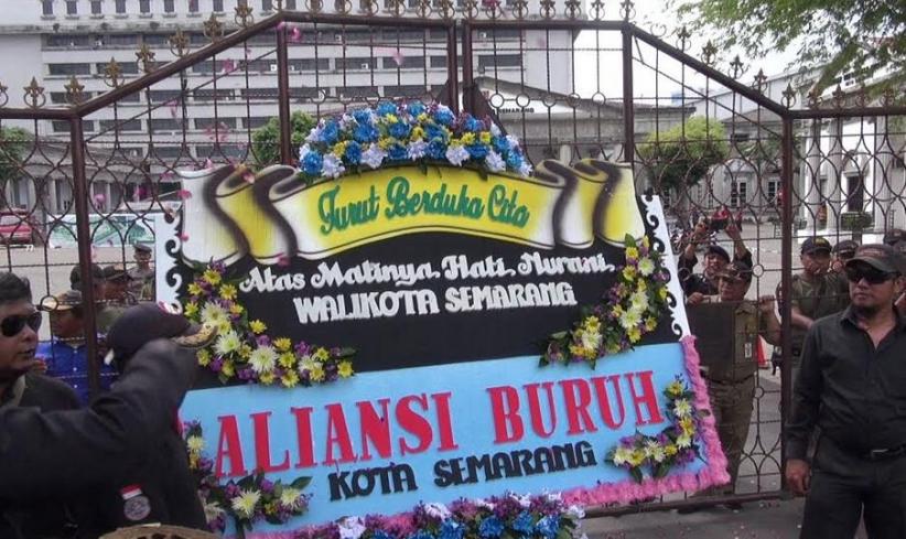 title Buruh Kirim Karangan Bunga Tanda Duka untuk Wali Kota dan Gubernur Buruh Kirim Karangan Bunga Tanda Duka untuk Wali Kota dan Gubernur