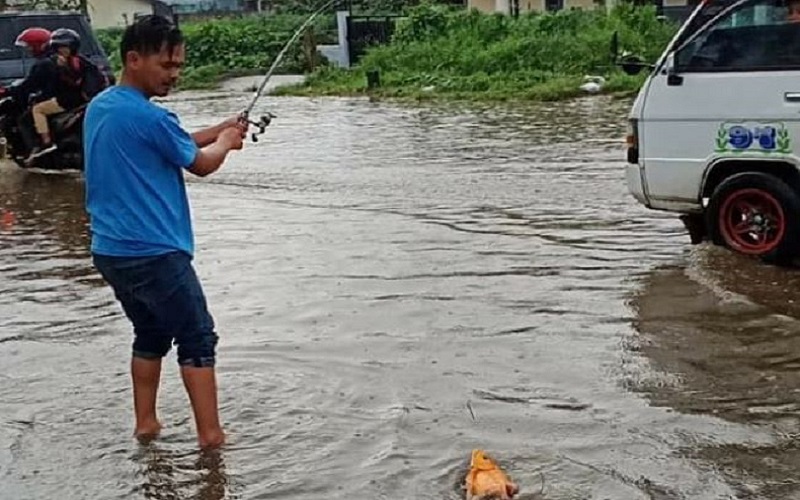 Kesal Jadi Langganan Banjir, Warga Protes dengan Mancing Ikan di Jalinsum Berastagi
