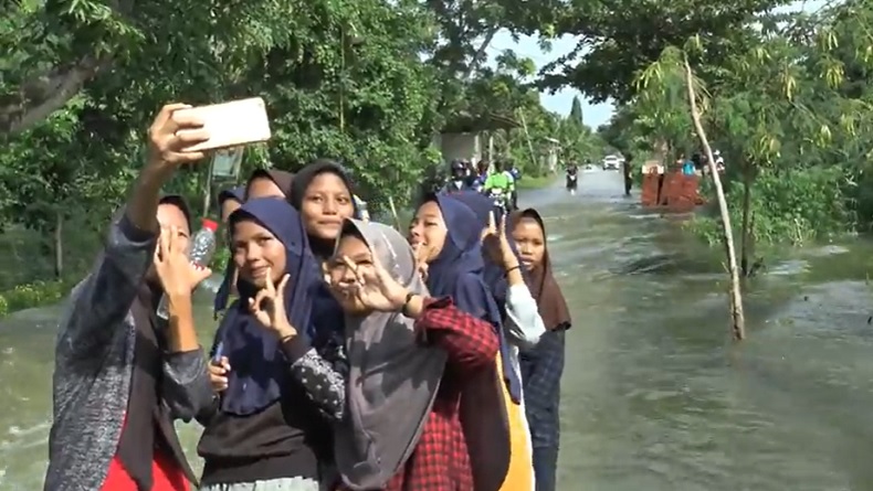 Sebagai Bentuk Kritik, Para Pelajar ini Berswafoto di Lokasi Banjir