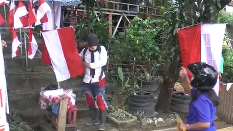 Unik! Penjual Bendera di Ambon Pakai Kostum Pejuang sedang Perang untuk Tarik Pembeli