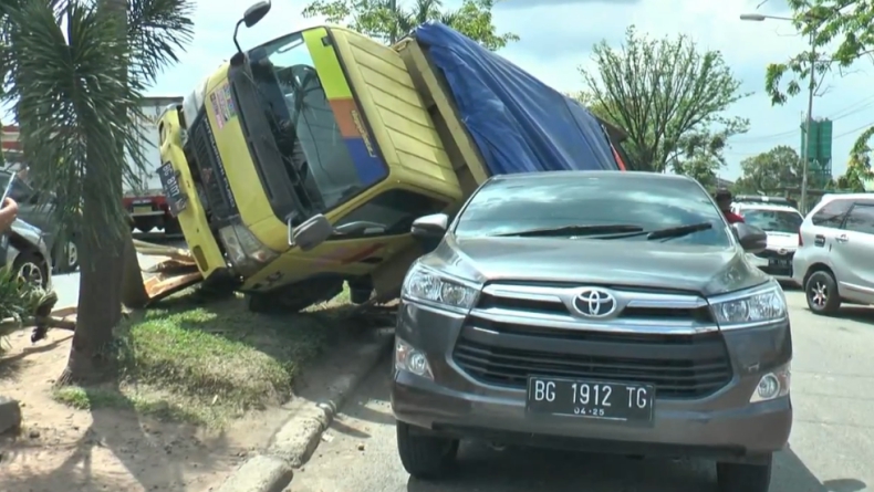 Hindari Tabrakan, Truk di Palembang Terbalik dan Timpa Innova