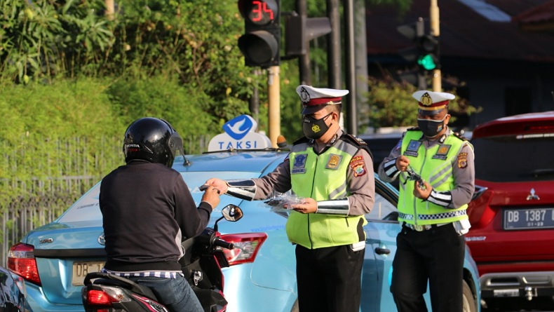 Atur Arus Lalin, Personel Ditlantas Polda Sulut Bagikan Masker Gratis Cegah Covid-19