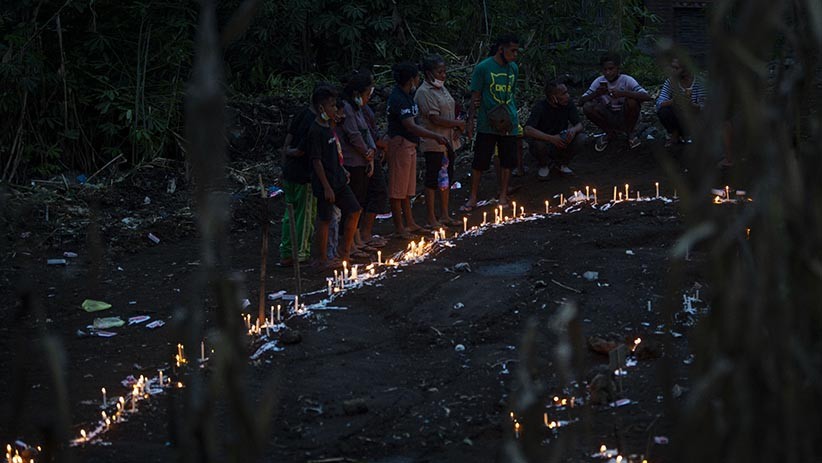 Warga Menyalakan Lilin di Atas Pemakaman Massal Korban Banjir Bandang NTT - Bagian 2