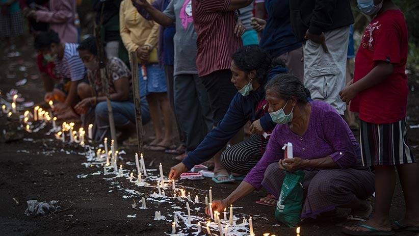 Warga Menyalakan Lilin di Atas Pemakaman Massal Korban Banjir Bandang NTT - Bagian 3