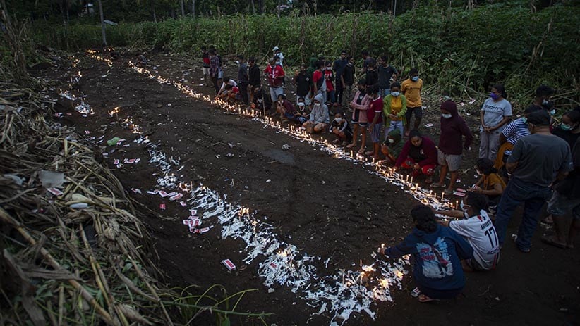 Warga Menyalakan Lilin di Atas Pemakaman Massal Korban Banjir Bandang NTT - Bagian 1