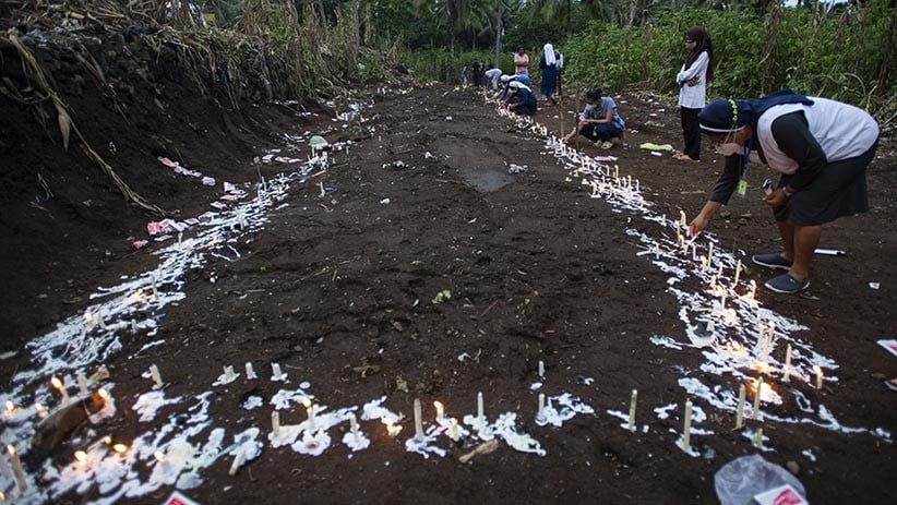 Warga Menyalakan Lilin di Atas Pemakaman Massal Korban Banjir Bandang NTT - Bagian 4