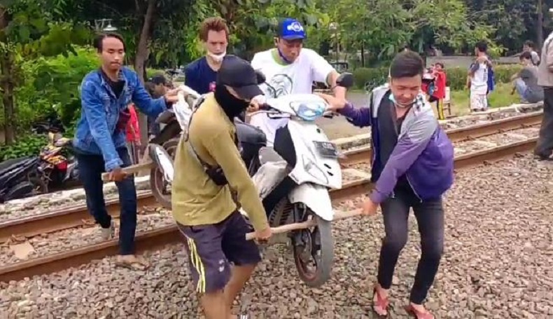 Hindari Penyekatan di Cirebon, Pengendara Nekat Gotong Motor Seberangi Rel Kereta
