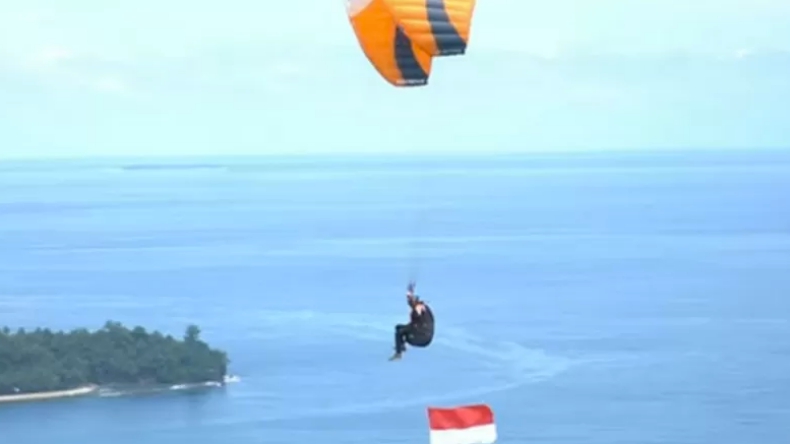 Pakai Paralayang, Polda Sumbar dan TNI AU Kibarkan Bendera Merah Putih di Udara
