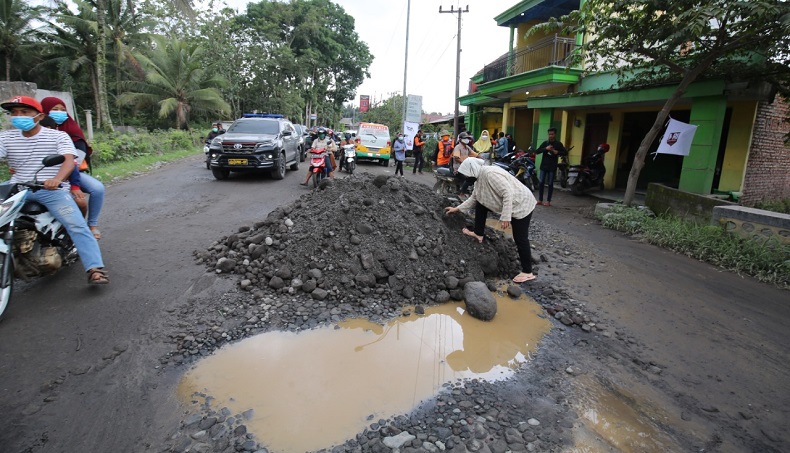 title  Mensos Risma Mengais Batu dan Pasir Tutupi Lobang Jalan saat Tinjau Pengungsi Semeru   Mensos Risma Mengais Batu dan Pasir Tutupi Lobang Jalan saat Tinjau Pengungsi Semeru