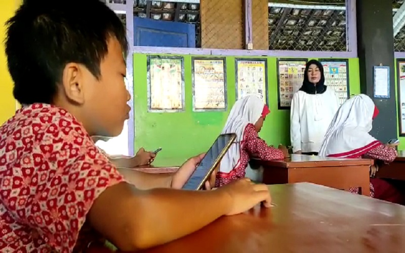 Sistem Online, Siswa SD di Lombok Timur Ujian Sekolah sambil Pegang HP