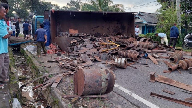 Tak Kuat Menanjak, Truk Bermuatan Besi Bekas Terbalik di Jalan Desa Jelutung 