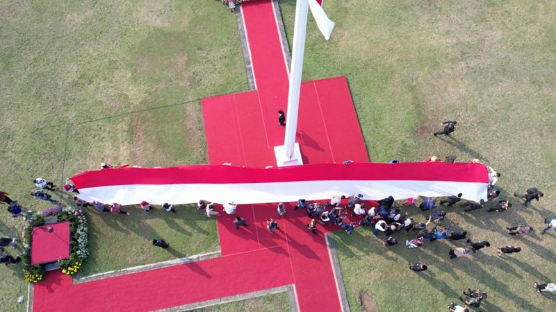 Buruh Migran Bentangkan Bendera Merah Putih Raksasa di Lapangan Pancasila Semarang