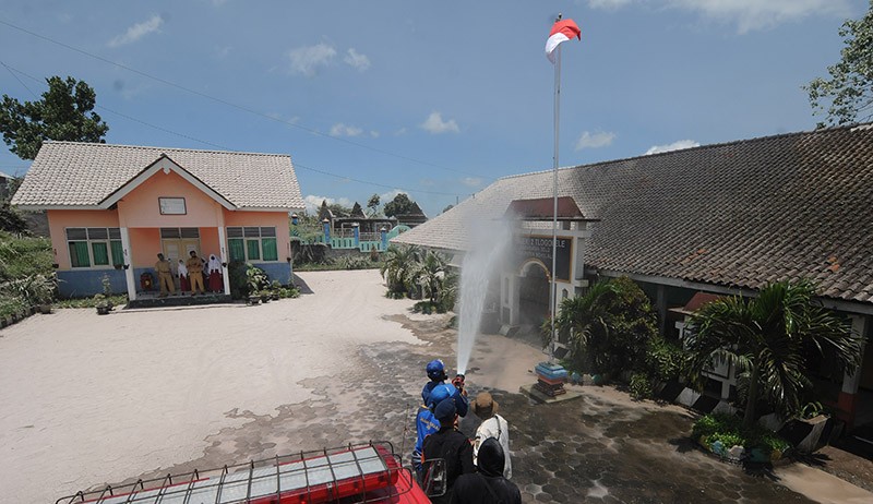 Petugas Gabungan Bersihkan Abu Vulkanik Gunung Merapi di Halaman Sekolah - Bagian 2