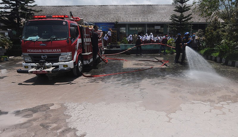 Petugas Gabungan Bersihkan Abu Vulkanik Gunung Merapi di Halaman Sekolah - Bagian 1